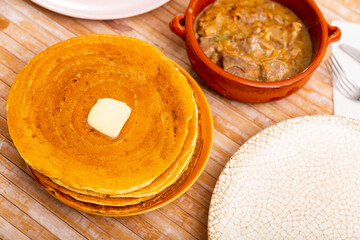 Puffy pancakes served with Machanka - stew with assorted meat, vegetables, mushrooms and sour cream