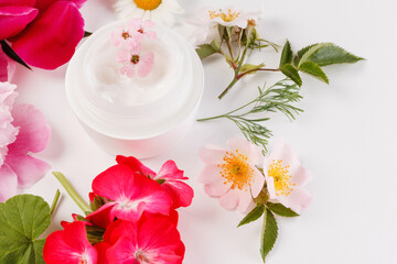 Fototapeta na wymiar cosmetic creams with pink flowers