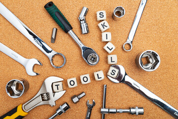 tools near cubes with TOOLS and SKILLS inscription on the cork table. View from above.