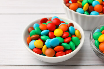 Tasty colorful candies on white wooden table, closeup