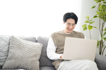 部屋でパソコンの仕事するアジア系の男性