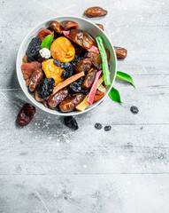 Assortment of different dried fruits in bowl.