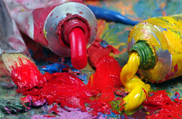 Tubes with art oil paint and brush on a palette. 