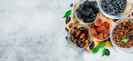 Assortment of different types of dried fruits in bowls.
