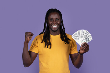 Emotional african american guy showing cash dollars and gesturing
