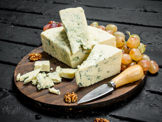 Blue cheese on a wooden Board with grapes.