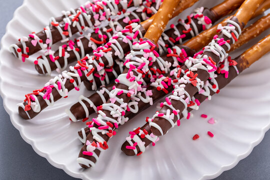 Valentines day treat, chocolate covered pretzel rods with sprinkles