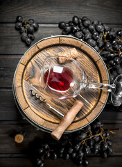 Wine background. Barrel with red wine and grapes.