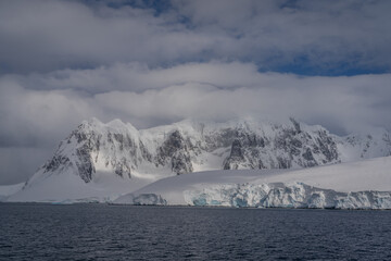 Great snowy Antarctic mountain above the sea