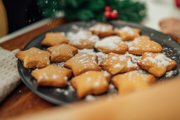 Top and side view of mother and daughter preparing gingerbread cookies with rolling pin in their kitchen in different shapes heart and stars 