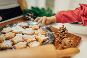 Top and side view of mother and daughter preparing gingerbread cookies with rolling pin in their kitchen in different shapes heart and stars 