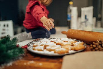 Top and side view of mother and daughter preparing gingerbread cookies with rolling pin in their kitchen in different shapes heart and stars 