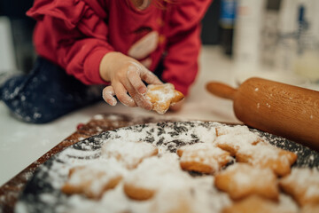 Top and side view of mother and daughter preparing gingerbread cookies with rolling pin in their kitchen in different shapes heart and stars 