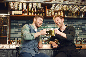 Men at bar behind bar with beer