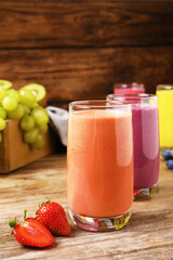 Glasses with tasty smoothies and ingredients on wooden table