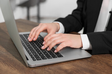 Woman working on laptop at wooden table closeup. Electronic document management