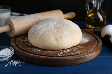 Fresh yeast dough and ingredients on blue wooden table