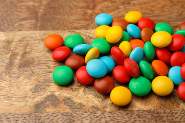 Fototapeta na wymiar Tasty colorful candies on wooden table, closeup