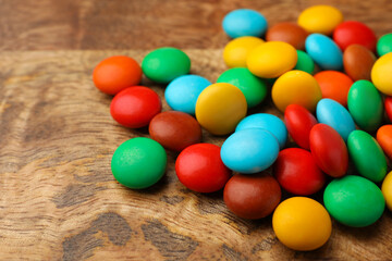 Fototapeta na wymiar Tasty colorful candies on wooden table, closeup