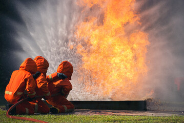 Firefighter Rescue training in fire fighting extinguisher. Firefighter fighting with flame using...