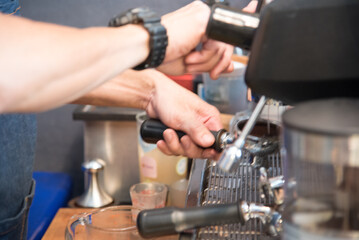 Obraz na płótnie Canvas Close up hands coffee barista man make hot cup espresso shot from coffee machine. Cappuccino with milk in italian coffee shop cafe. Close up hands of barista use machine make black drinking hot cup