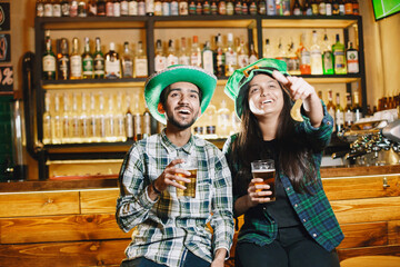Obraz premium Indian friends celebrate St. Patrick's Day in a pub