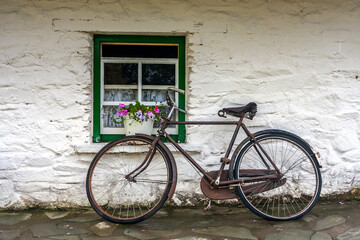 Traditional Irish scene with the old bike by the window of the thatch roof cottage © peteleclerc