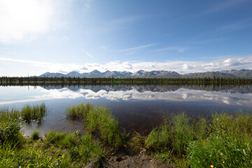 mountain range with small pond in alaska 