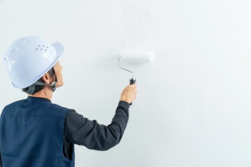 壁を塗装する職人　塗装工　塗装職人