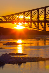 Naklejka na ściany i meble Sun setting behind Quebec City's Old Bridge.