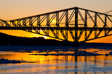 Sun setting behind Quebec City's Old Bridge.