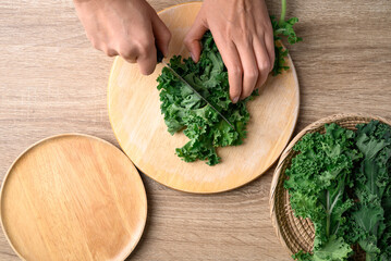 Green Kale or leaf cabbage cutting on wooden board, Healthy vegetable, Table top view
