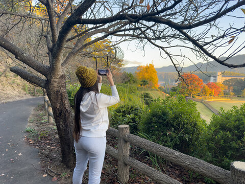 girl photographing in a beautiful park