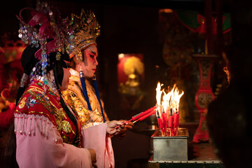 Male and female Chinese opera actors Light a candle to pray homage to the gods to enhance the prosperity for yourself on the occasion