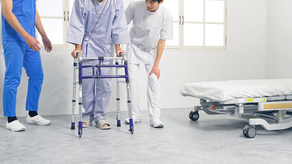 歩行器を使ってリハビリする患者とケアスタッフ