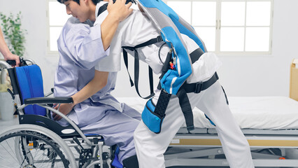パワーアシストスーツをつけて患者を抱える看護師　移乗介助機器