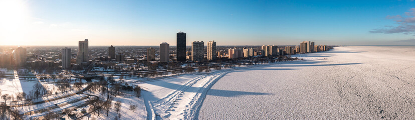 Beautiful aerial panorama of the residential highrise buildings casting shadows onto a frozen Lake...