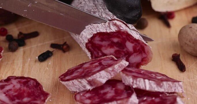 Slicing pork sausage with white mold , dried meat with spices and in white mold close - up