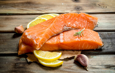 Raw salmon steaks with lemon wedges.