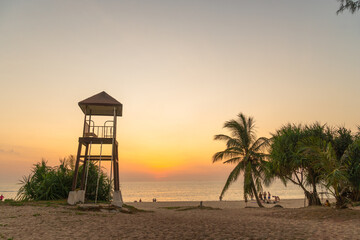 colorful bright sky of sunset behind lifeguard tower at Karon beach..Karon beach is broad and long...