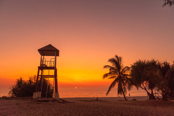colorful bright sky of sunset behind lifeguard tower at Karon beach..Karon beach is broad and long Sand and beautiful beach..4k stock footage video in travel concept. bright sky background