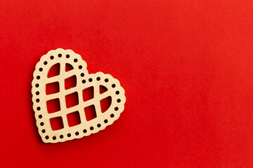 Minimalistic red Valentine's Day background with wooden decorative heart, flat lay, copy space.