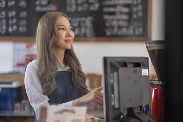 Fototapeta na wymiar Opening a small business, A Happy Asian woman in an apron standing near a bar counter coffee shop, Small business owner, restaurant, barista, cafe, Online, SME, entrepreneur, and seller concept
