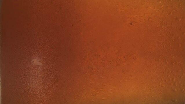 close-up of a rotating glass with cold fizzy beer