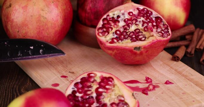 Cut juicy ripe red pomegranate , cut with a sharp knife of ripe pomegranate during cooking