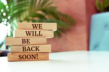 Wooden blocks with words 'We will be back soon!'.