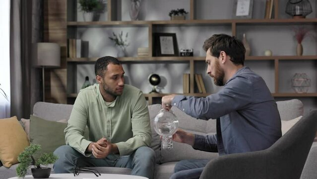 A visit to an African American psychologist. A man sits on a couch and talks to a psychotherapist. Depression, apathy, stress, burnout at work. Help of a psychologist.