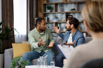 A family psychologist conducts a session in a beautiful office. LGBT couple at a psychotherapist's appointment. Psychologist for gays. Support for the LGBT community in visiting a psychologist.