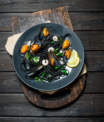 Mediterranean food. Spaghetti with cuttlefish black ink and clams.