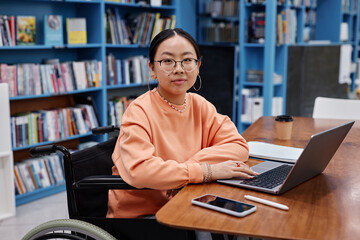 Asian young woman with disability as college student looking at camera